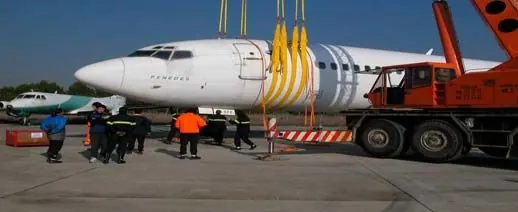Lifting slings raising an aircraft fuselage with a crane
