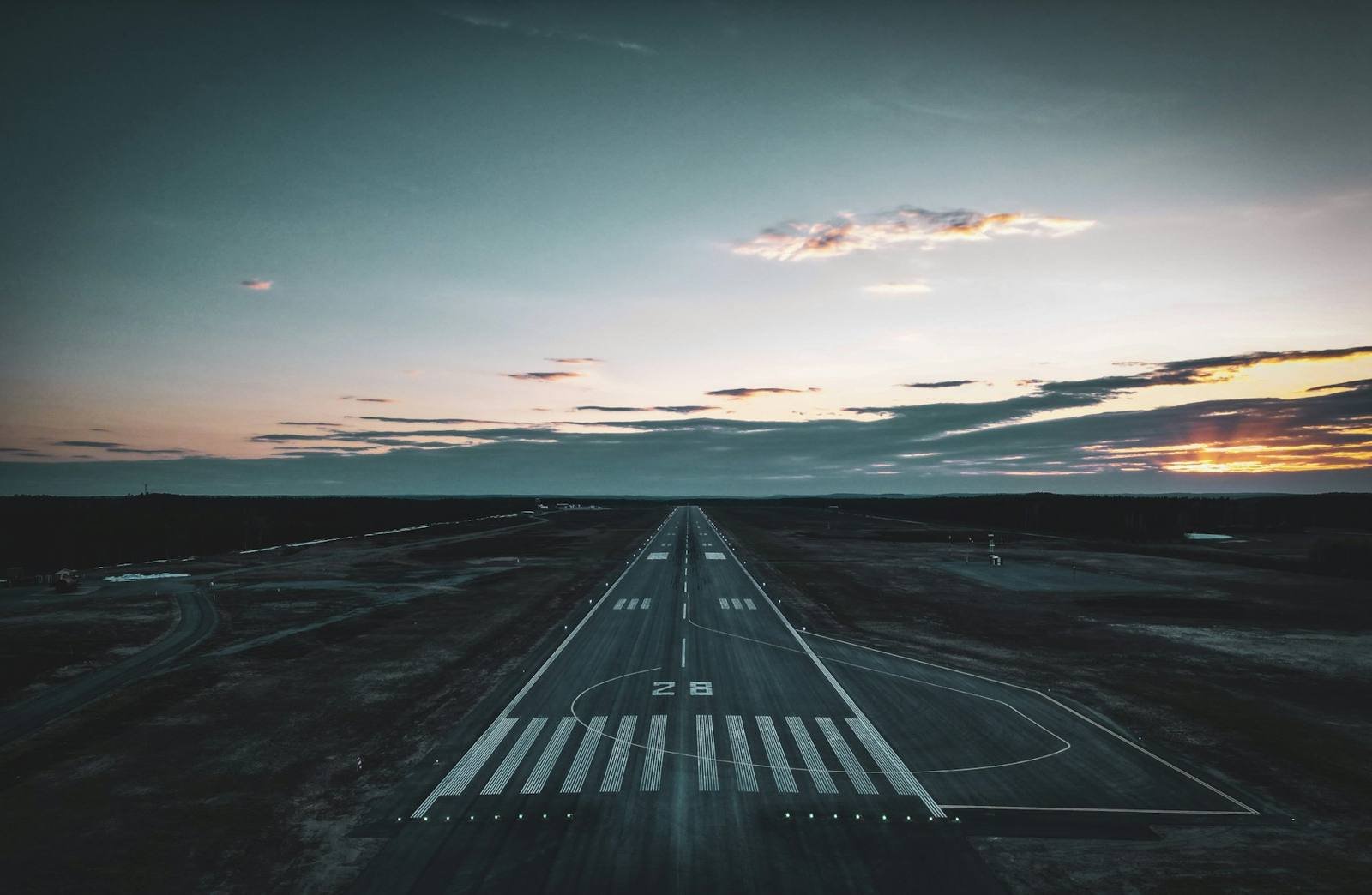 Airport runway at dusk with threshold markings