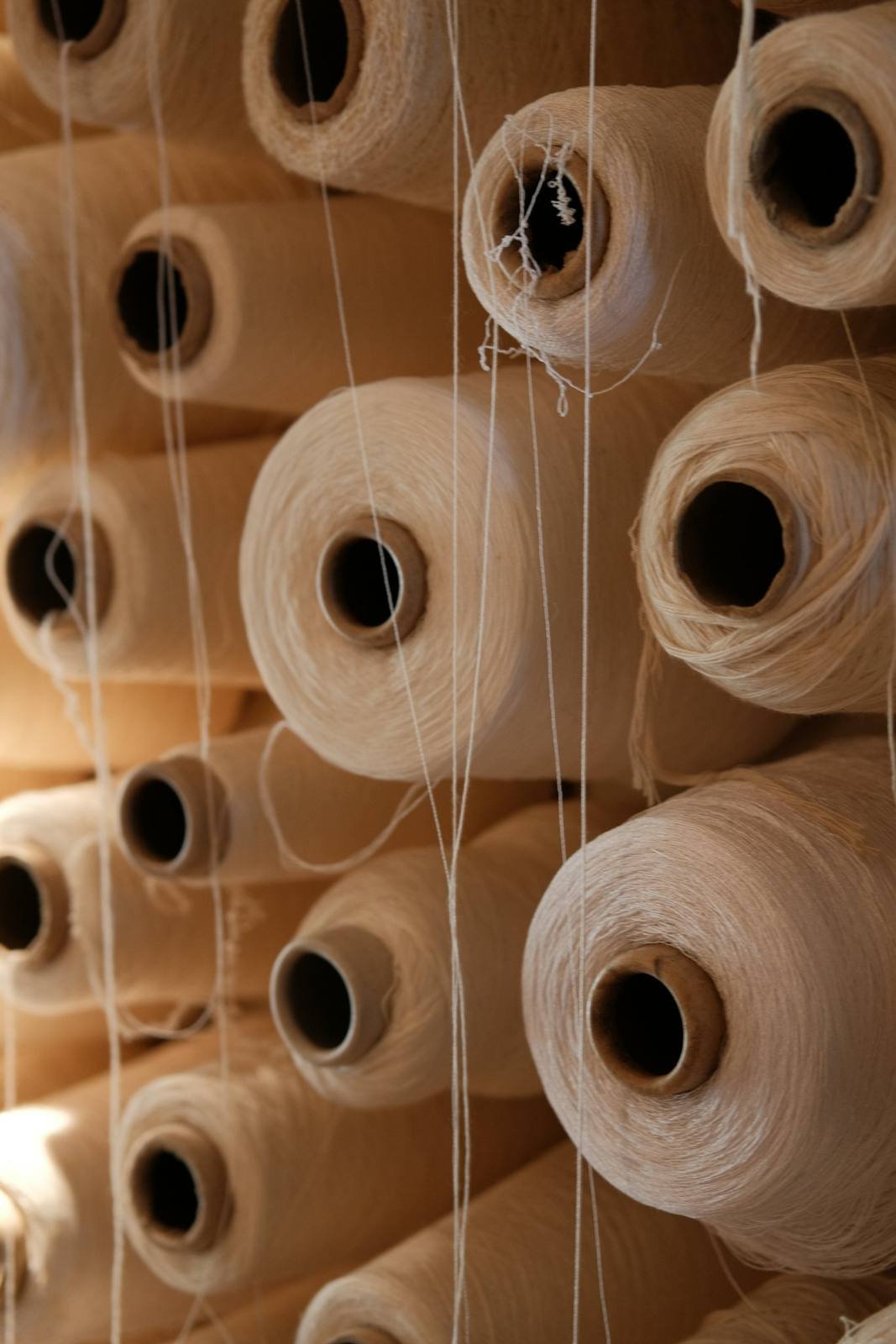 Stacked spools of white cotton yarn